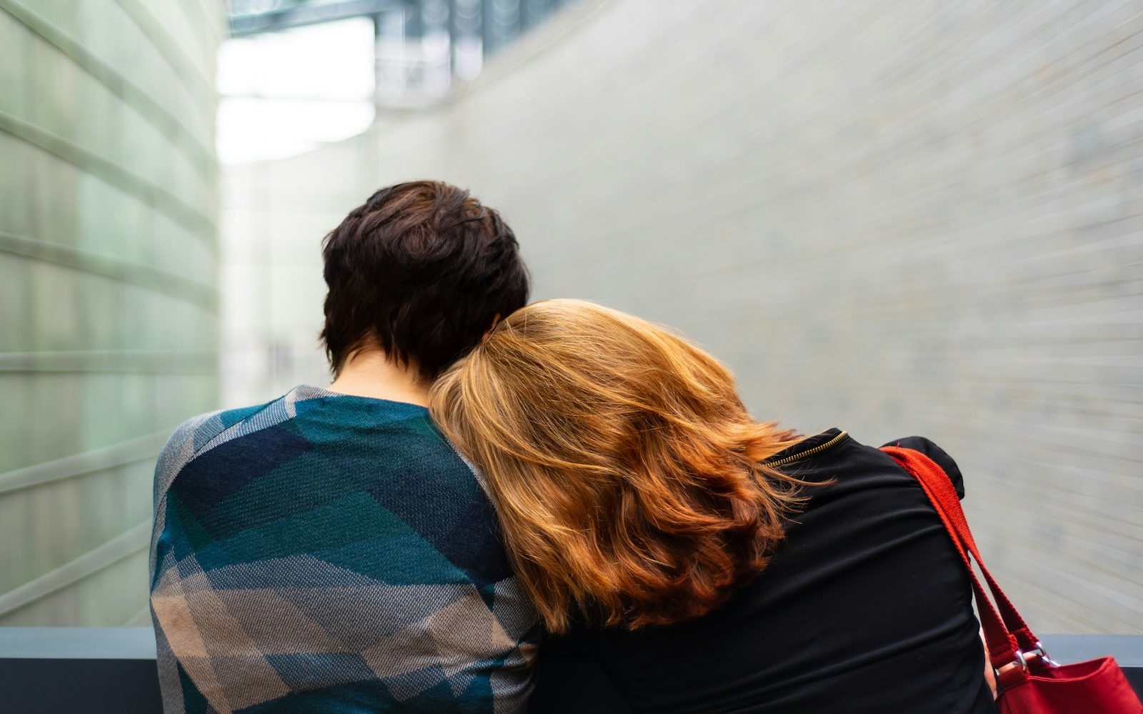 a woman rests her head on another person's shoulder